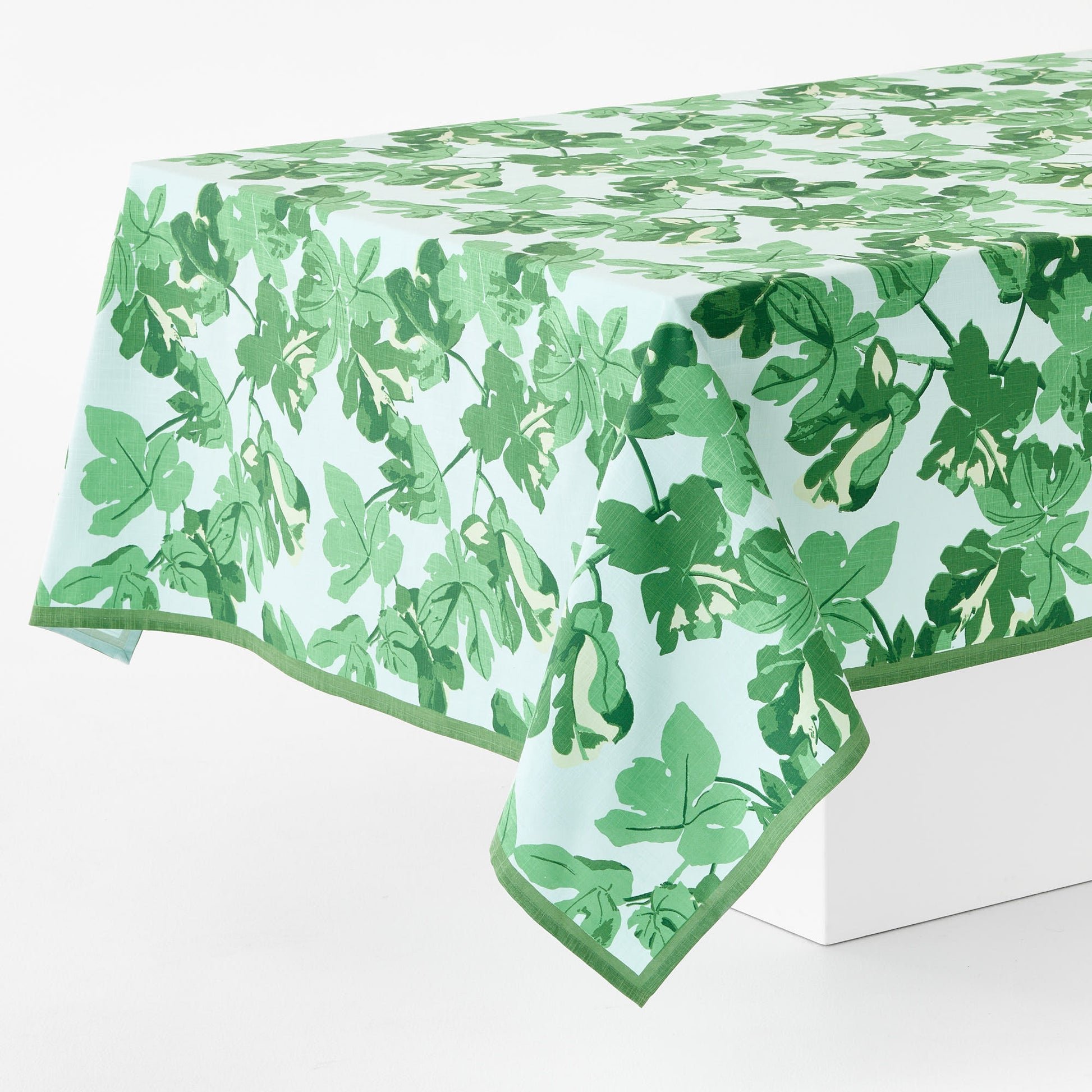 Peter Dunham cotton slub tablecloth with green fig leaf print on pale blue background, 108x70 inches.