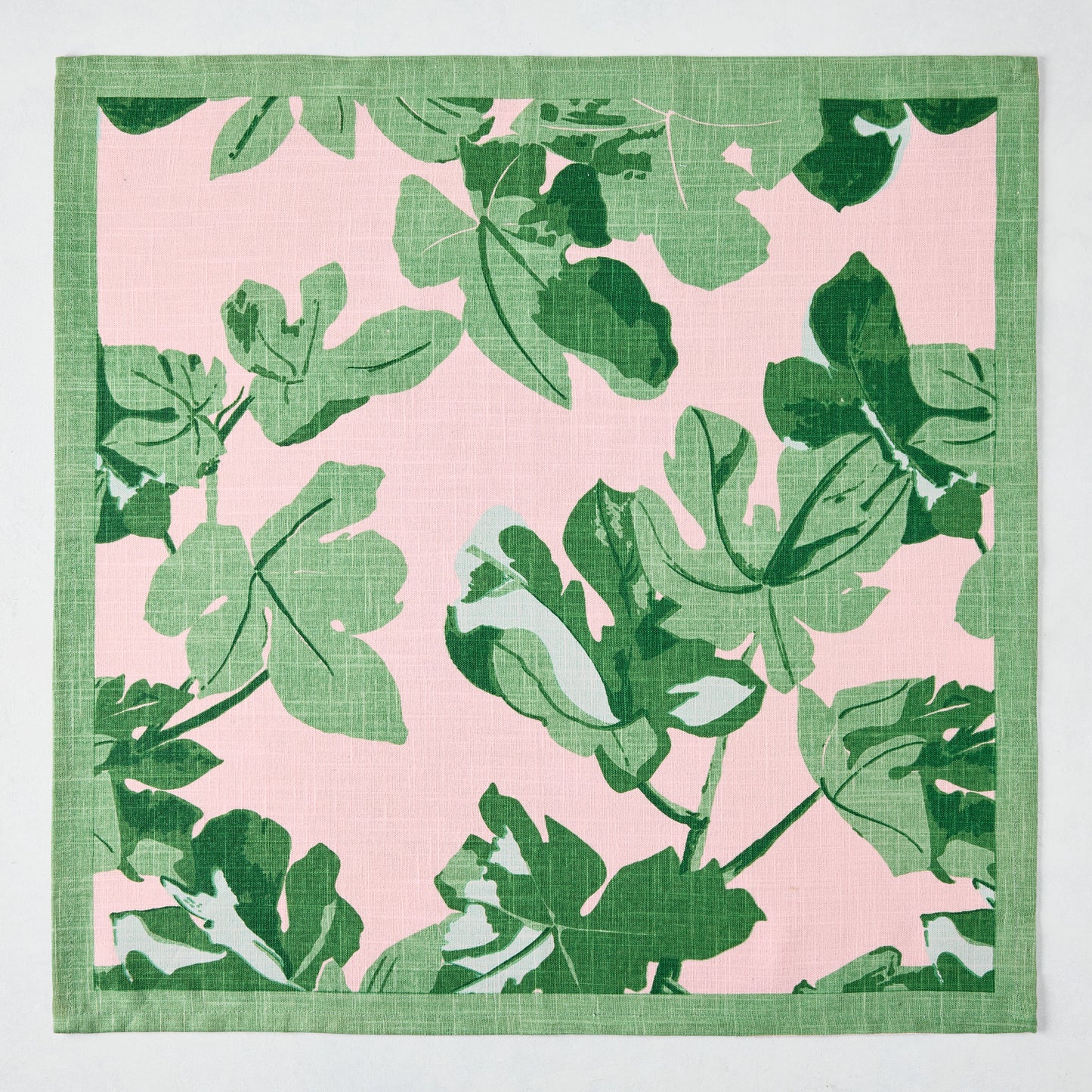 Peter Dunham + Hudson Grace Green Fig Leaf printed pale pink cotton slub napkin with green border.