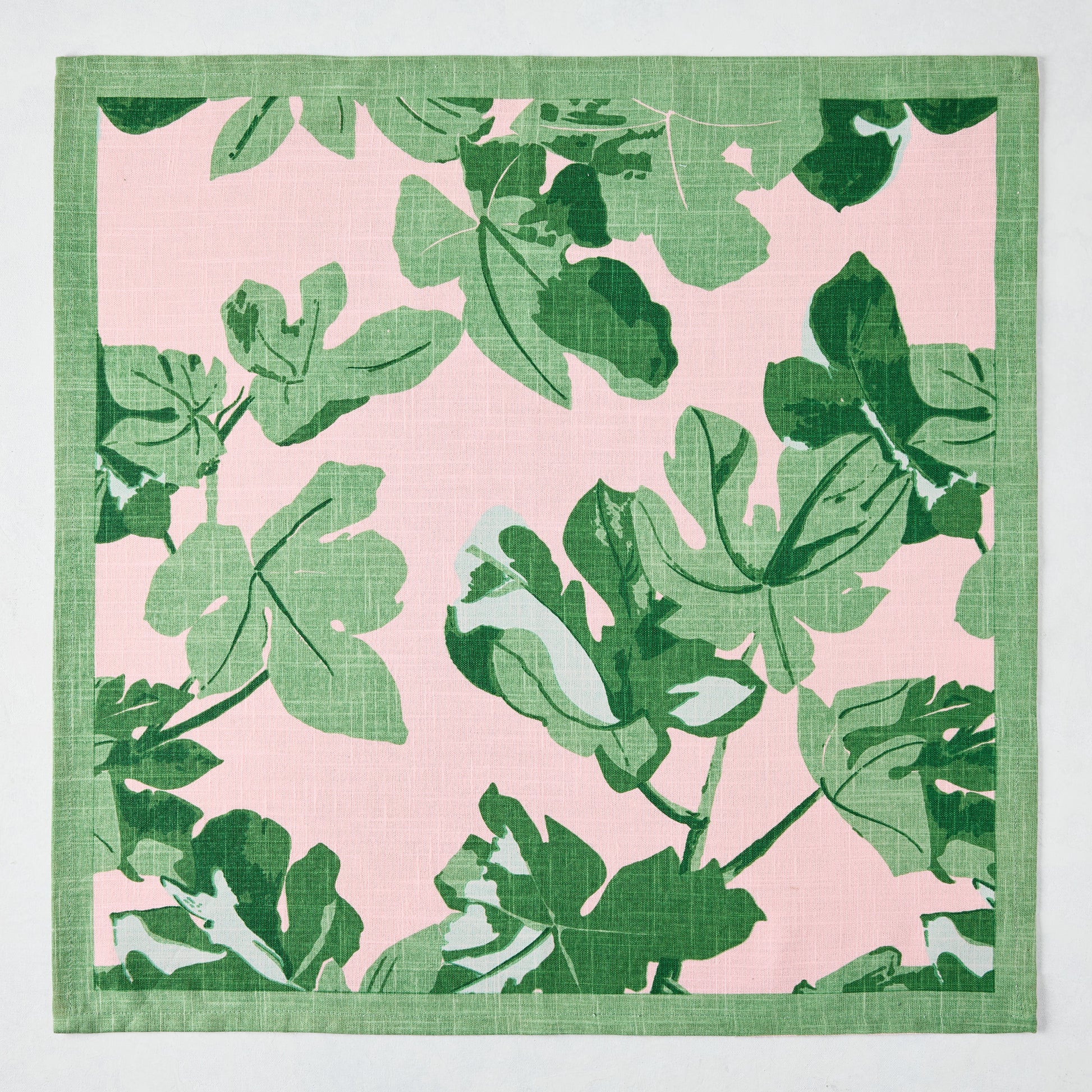 Peter Dunham + Hudson Grace Green Fig Leaf printed pale pink cotton slub napkin with green border.