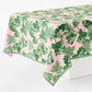 Rectangular 108x70 inch cotton slub tablecloth with green fig leaf print on a pink background and green border.