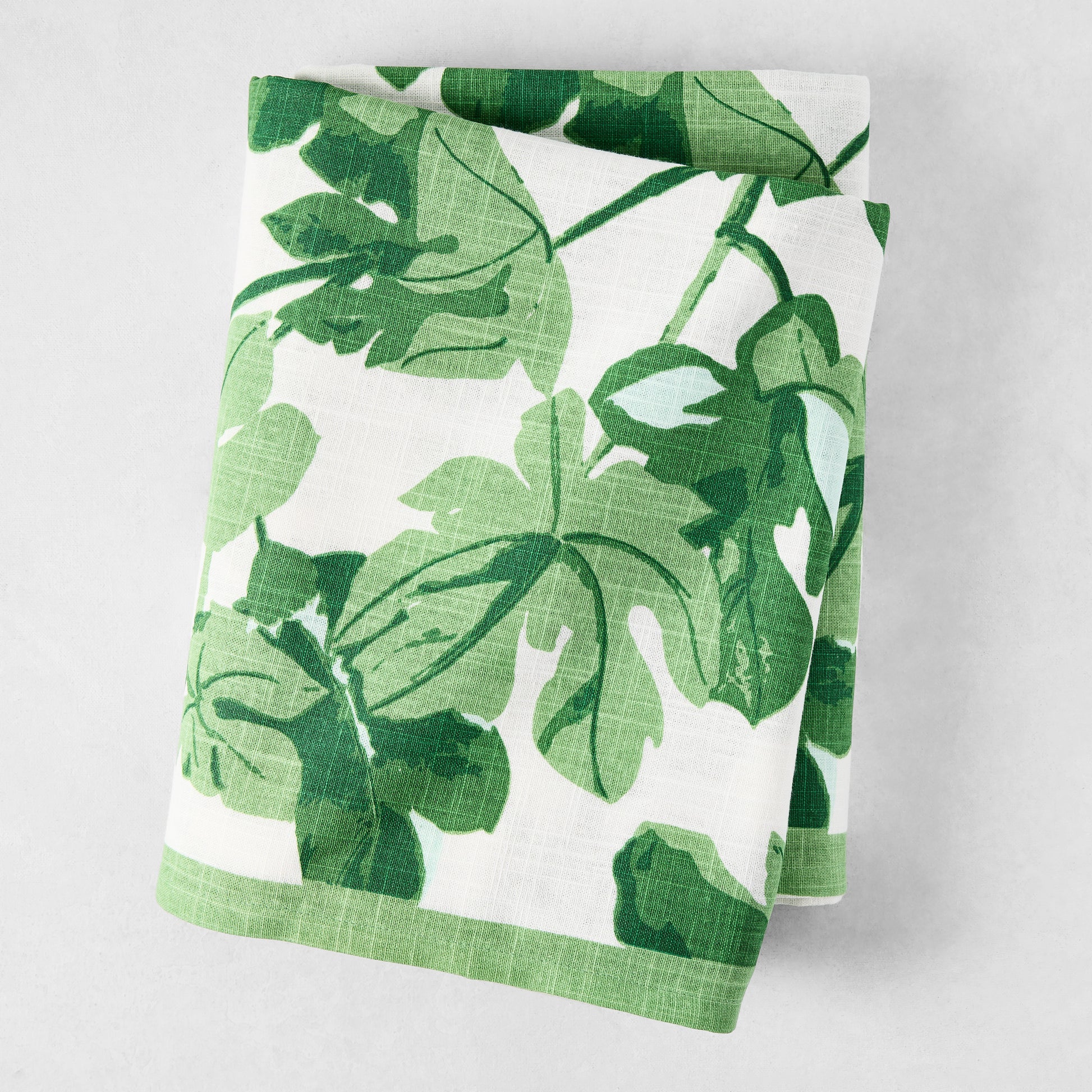 Peter Dunham + Hudson Grace Green Fig Leaf Printed White Tablecloth, 100% cotton slub, folded.