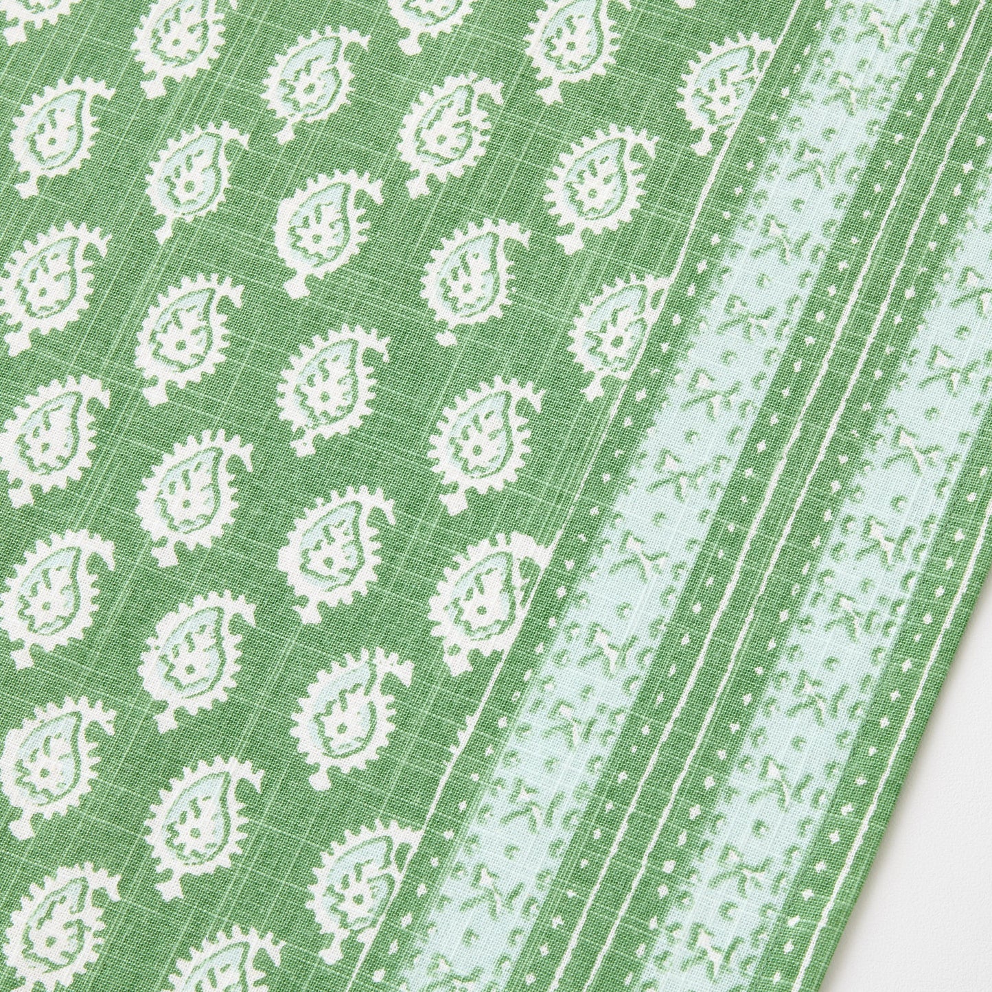 Green cotton slub table runner with white paisley print and graphic border detail from Peter Dunham + Hudson Grace.