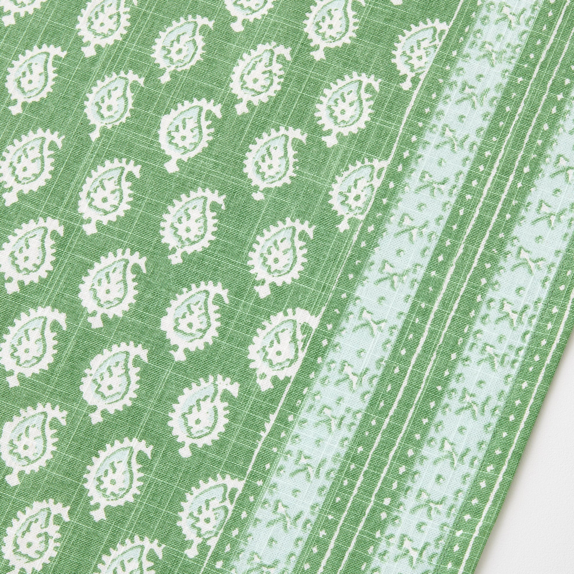Green cotton slub table runner with white paisley print and graphic border detail from Peter Dunham + Hudson Grace.