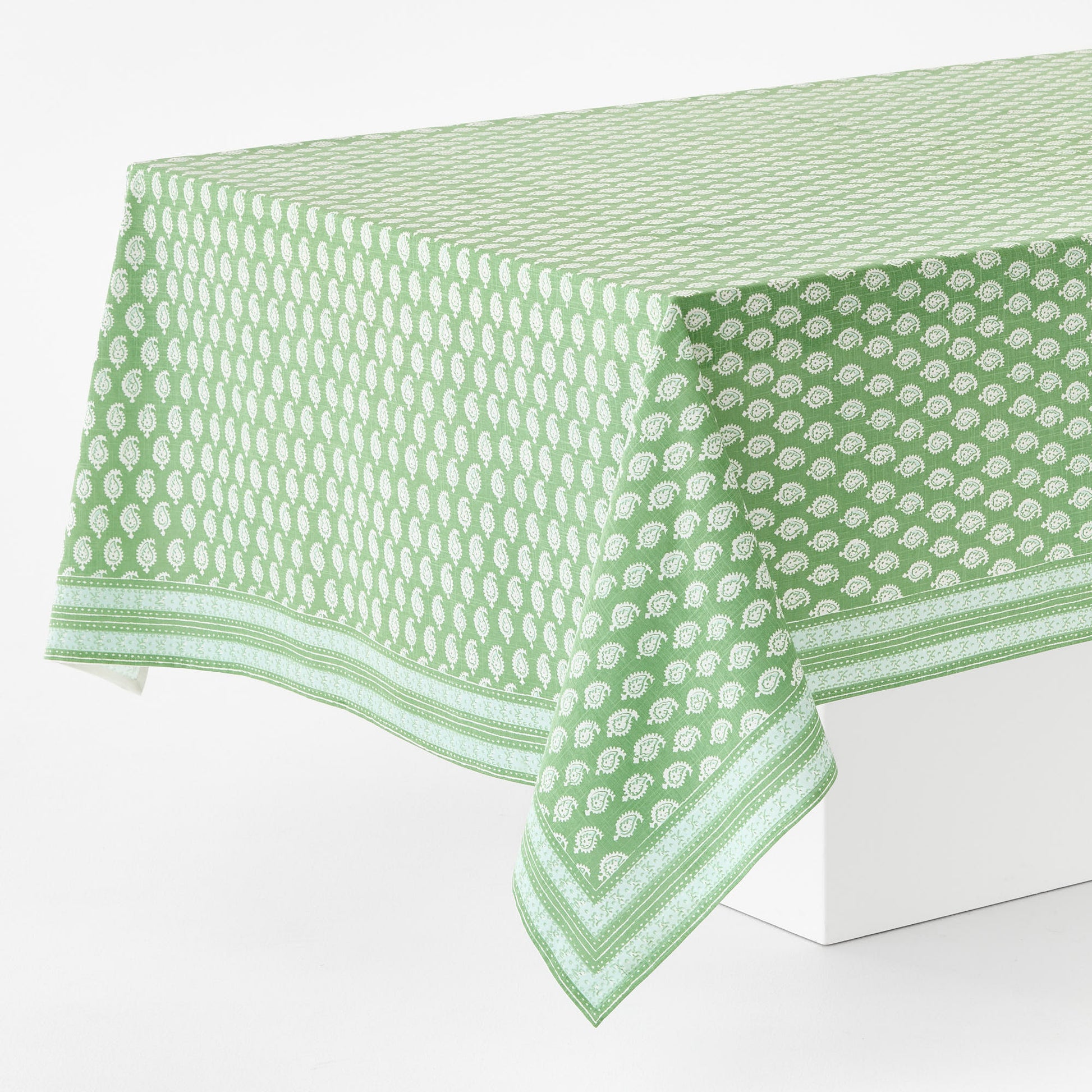 Green 100% cotton rectangular tablecloth with white paisley print and graphic border by Peter Dunham + Hudson Grace.