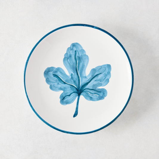 Peter Dunham + Hudson Grace hand-painted white appetizer plate with a single blue fig leaf and blue border.