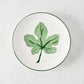 Peter Dunham + Hudson Grace hand-painted white appetizer plate with a green fig leaf and green border.