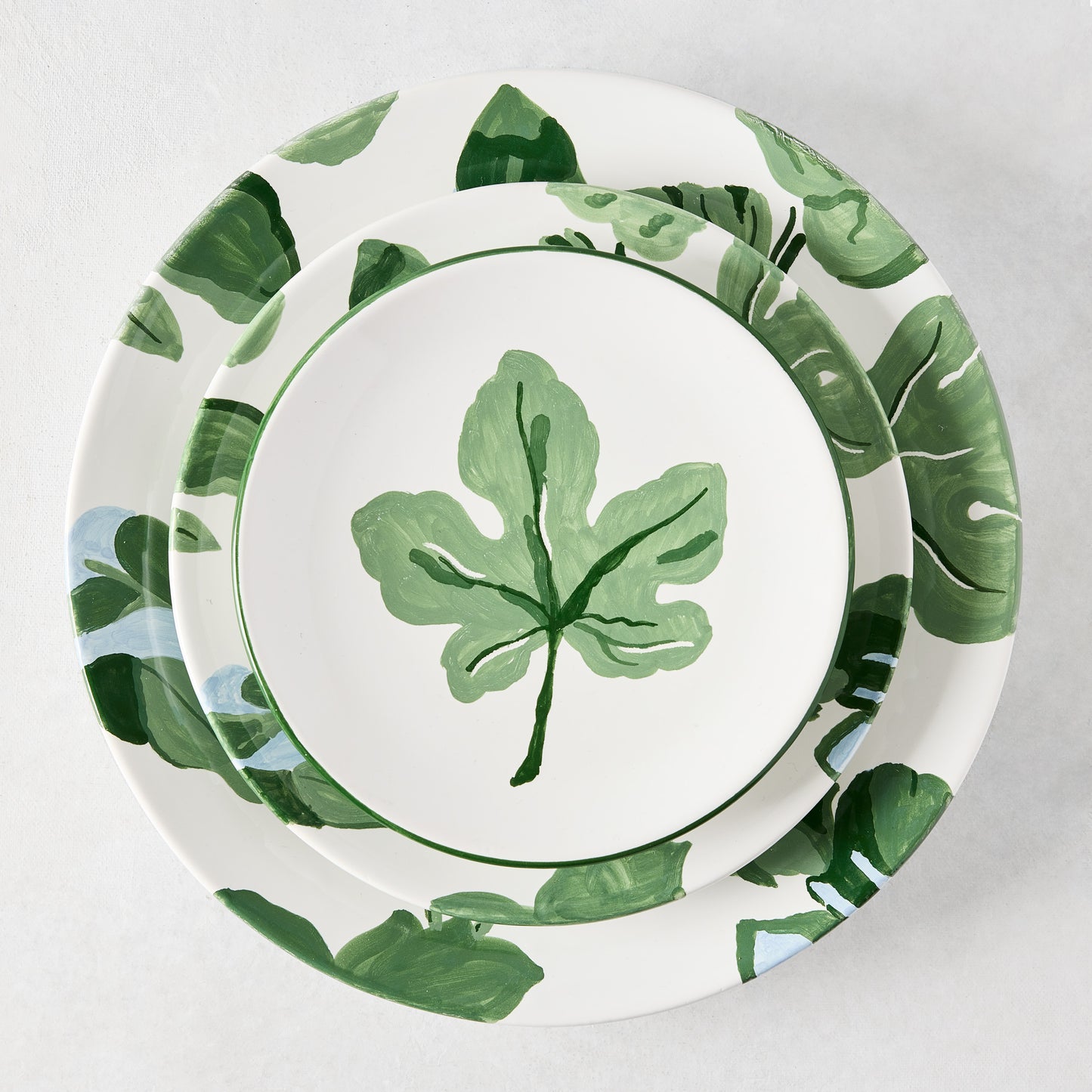 Peter Dunham + Hudson Grace hand-painted white ceramic dinner and salad plates with green fig leaf pattern.