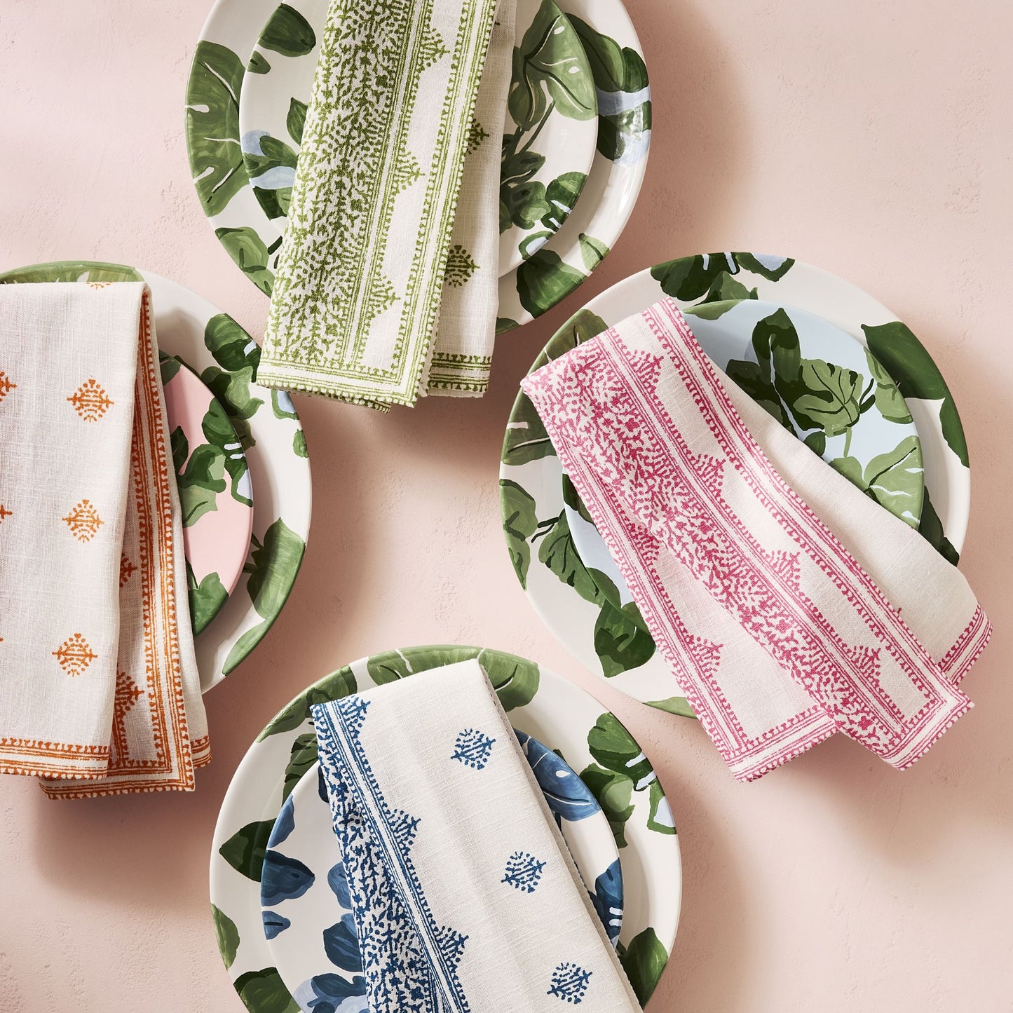 Peter Dunham + Hudson Grace hand-painted ceramic salad plates with green fig leaf patterns and colorful patterned napkins.