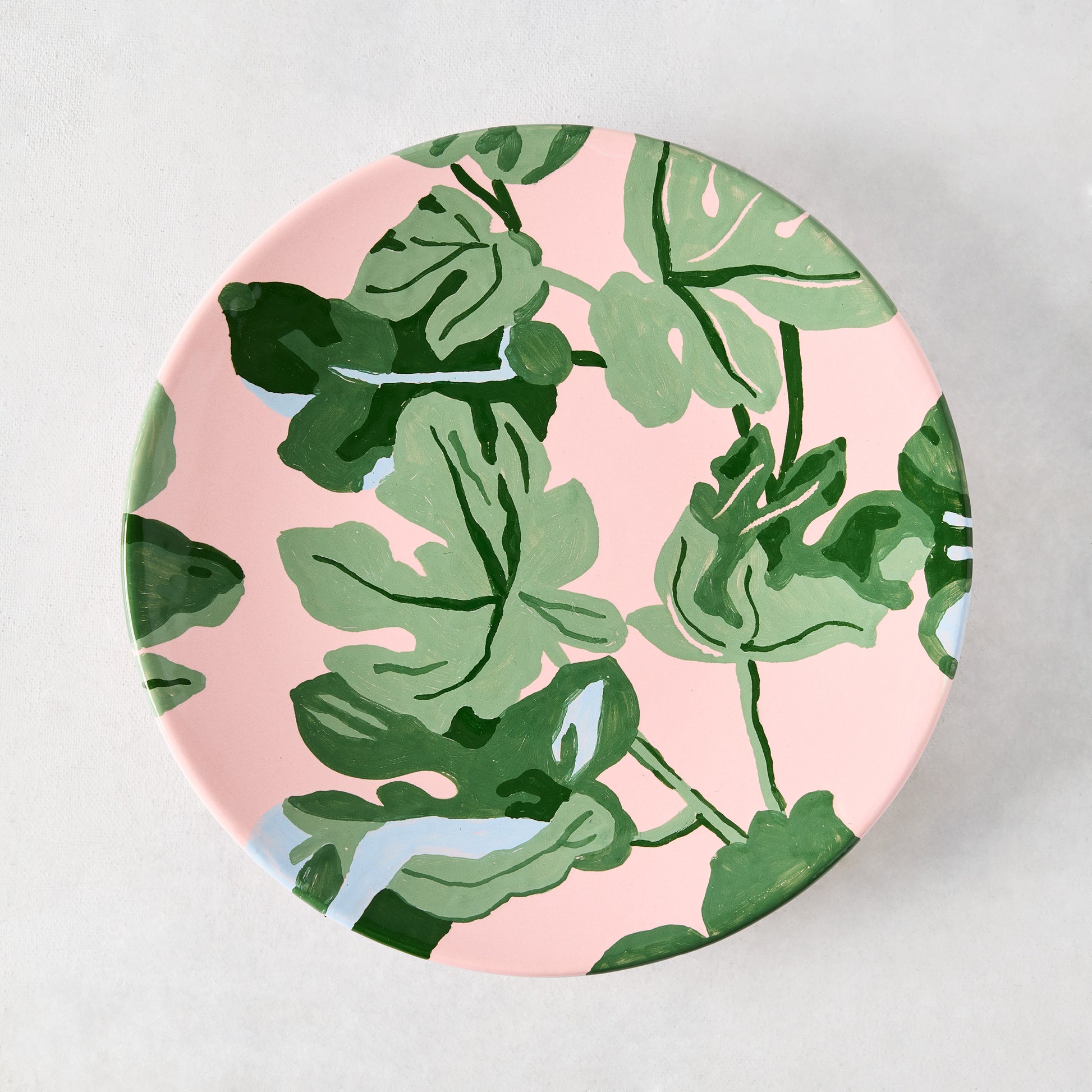 Peter Dunham + Hudson Grace pink ceramic salad plate with hand-painted green fig leaf pattern.