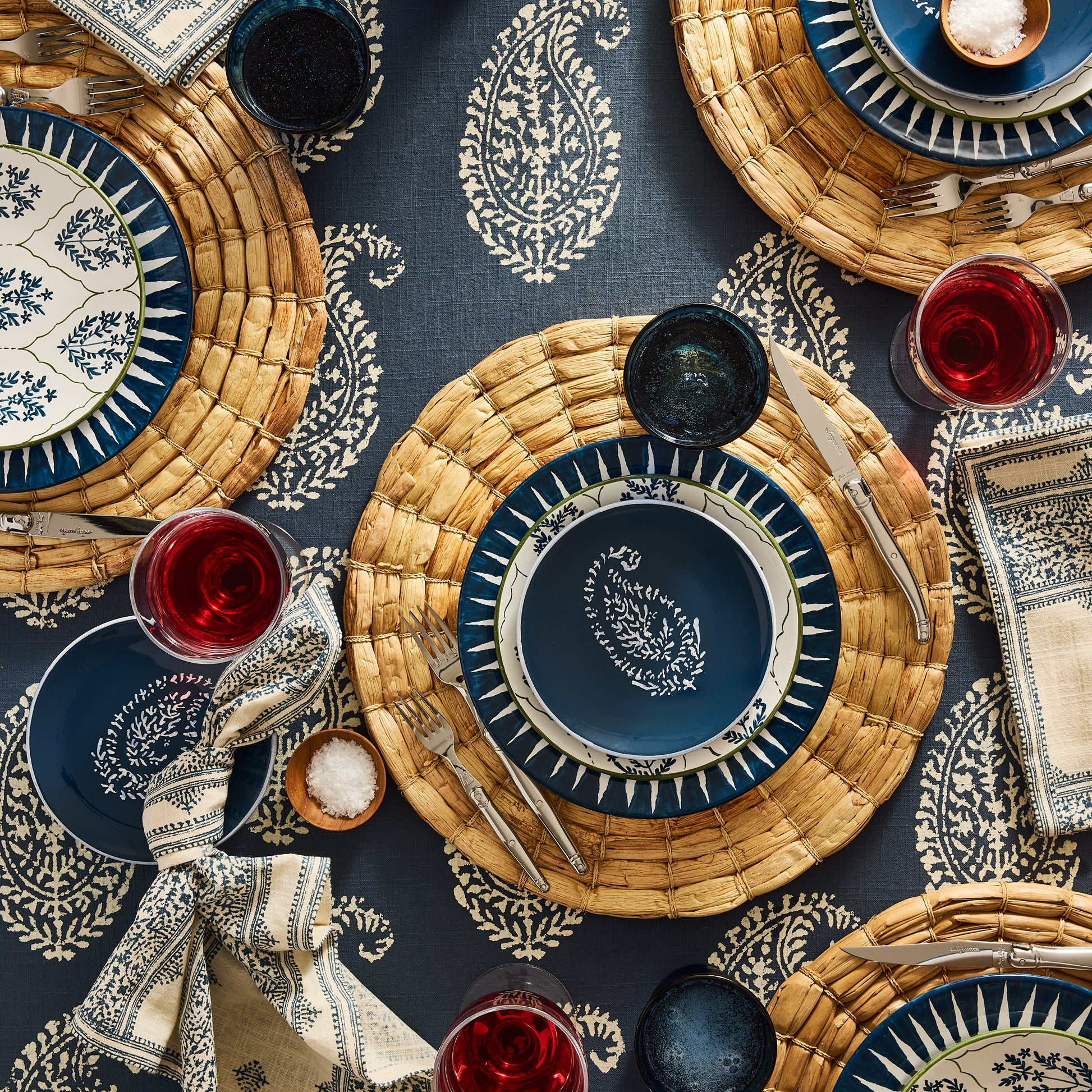 Peter Dunham + Hudson Grace Indigo Blue Hand-Painted Sunburst Dinner Plate on a woven placemat.