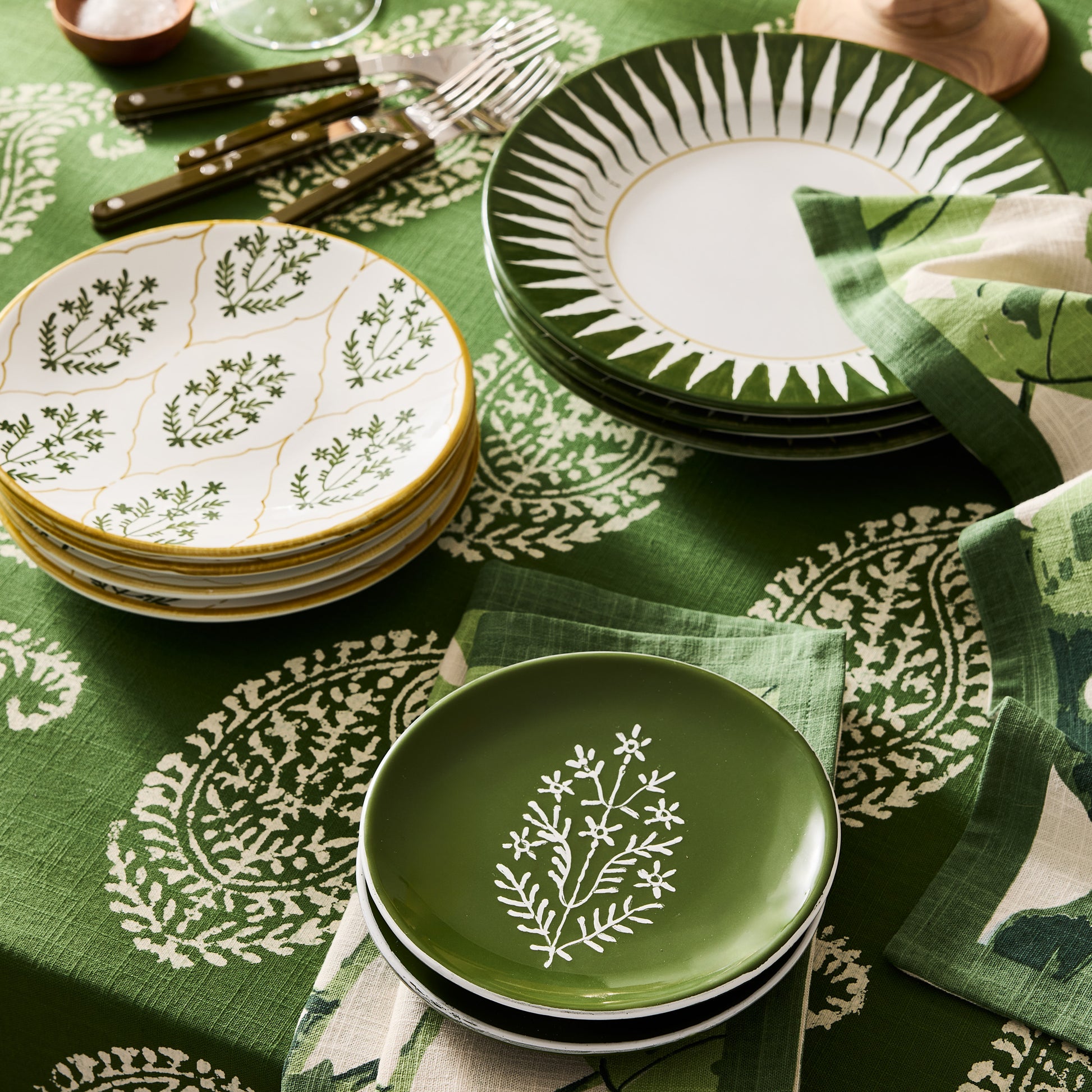 Peter Dunham + Hudson Grace Olive Green Hand-Painted Jaali Salad Plate with white floral pattern on a green tablecloth.