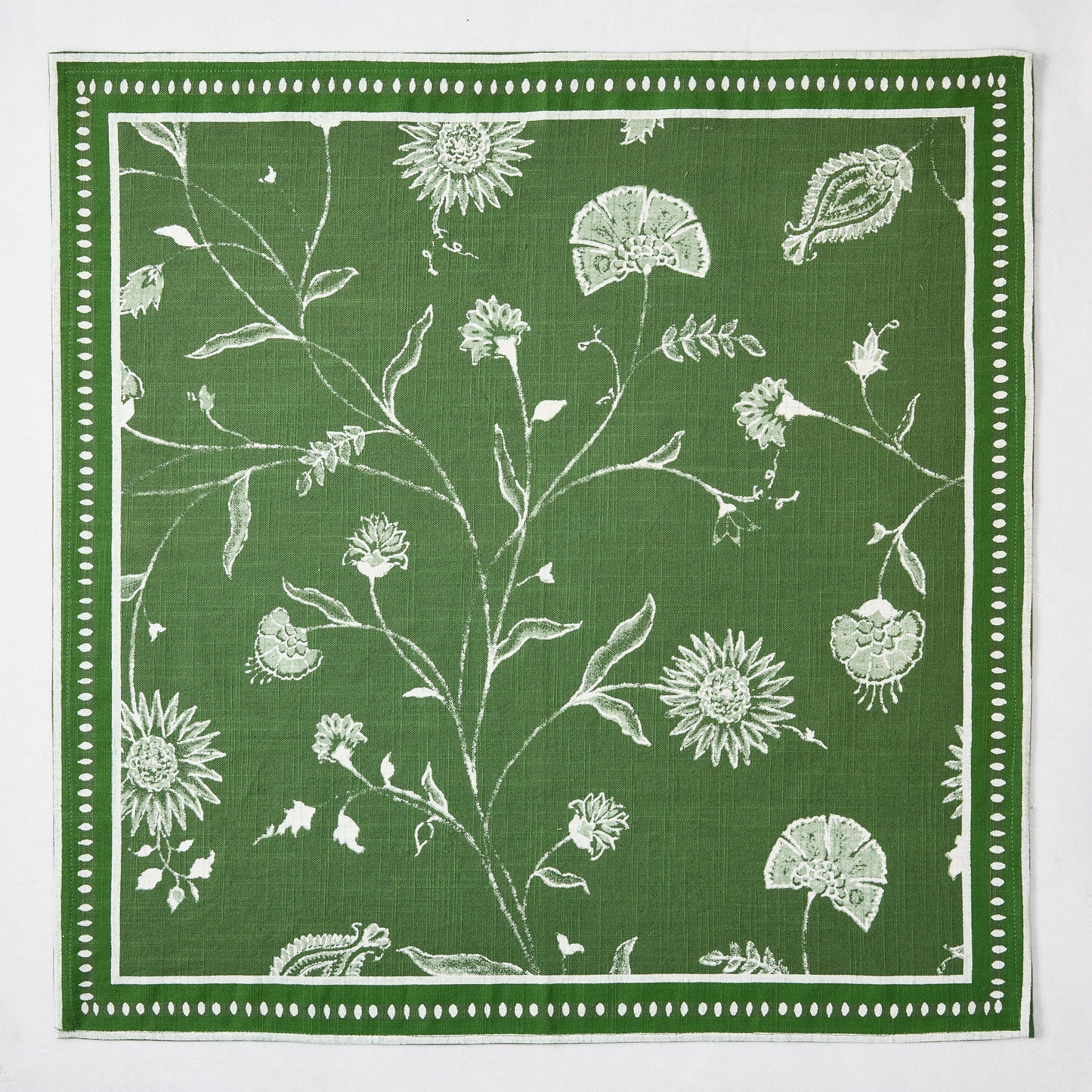 Olive green Indian Chintz printed napkin with white rambling floral pattern and antique rug-inspired border.