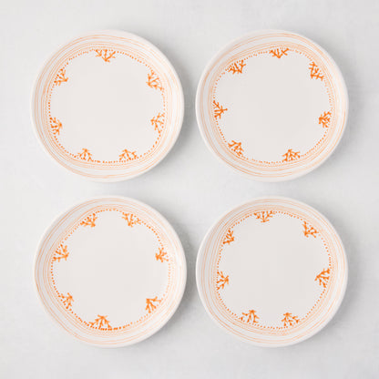 Four white Peter Dunham + Hudson Grace Orange Fez appetizer plates with hand-painted coral borders.