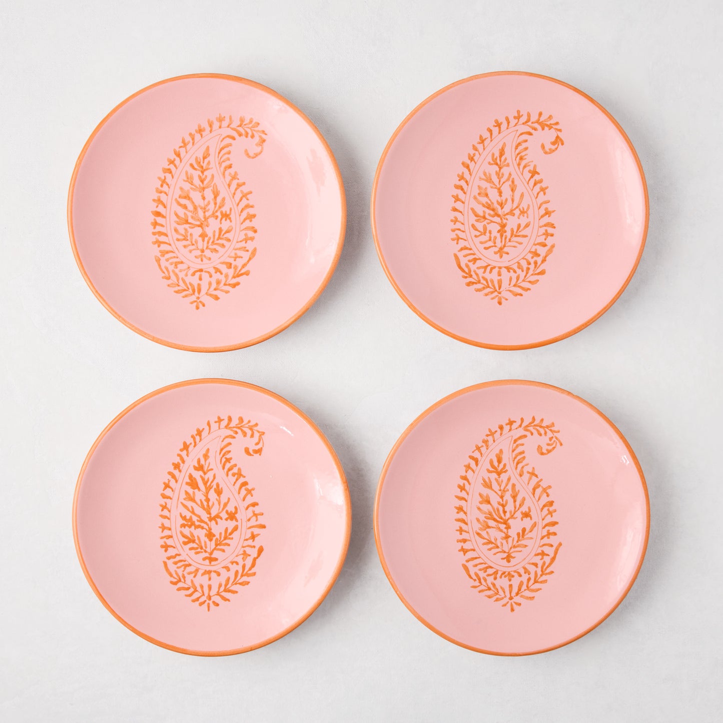 Four Peter Dunham + Hudson Grace pink hand-painted Kashmir Paisley appetizer plates with orange trim.