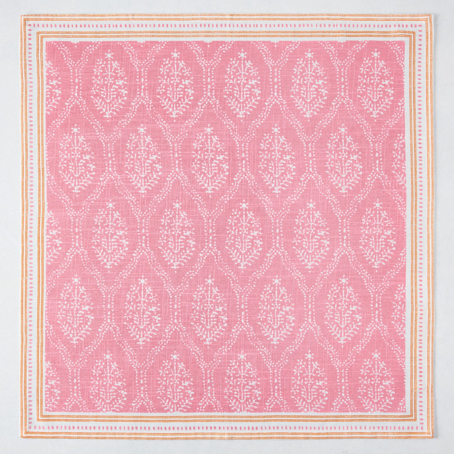 Pink Jaali printed cotton slub napkin with white floral pattern and orange border.