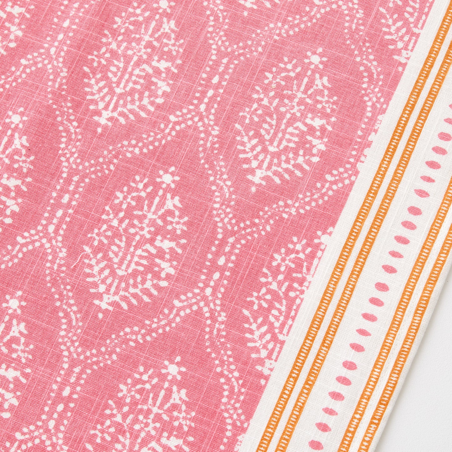 Peter Dunham pink cotton slub table runner with white Jaali floral block print and orange striped border.