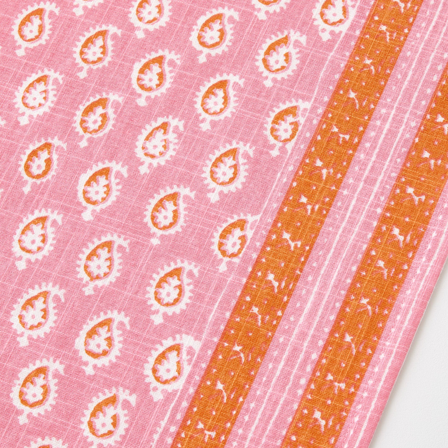 Pink cotton slub table runner with orange paisley print and graphic border detail by Peter Dunham + Hudson Grace.