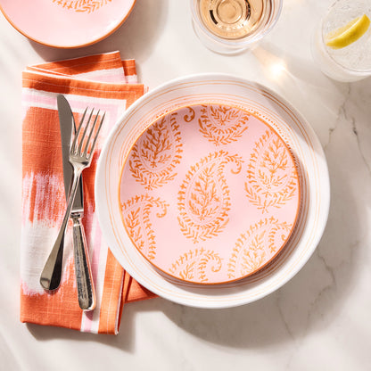 Pink Kashmir hand-painted paisley salad plate by Peter Dunham + Hudson Grace, with orange napkin and silverware.