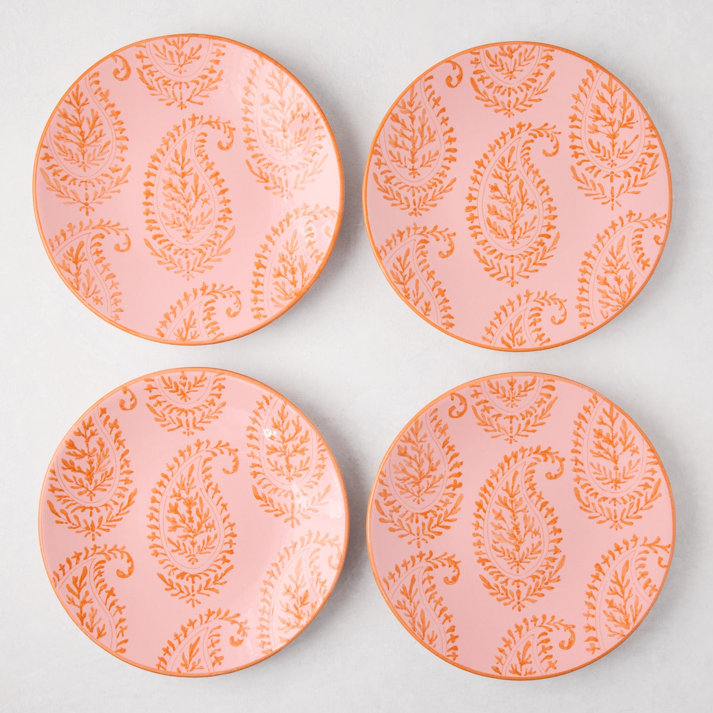 Four Peter Dunham + Hudson Grace Pink Kashmir hand-painted paisley salad plates with orange trim.