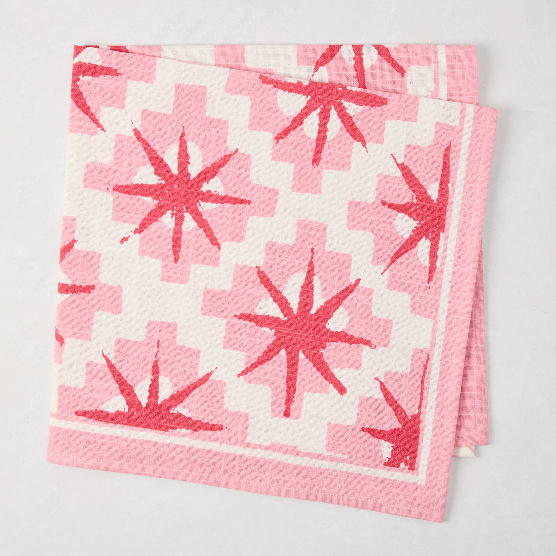 Peter Dunham + Hudson Grace Pink Starburst Printed Napkin, 100% cotton slub, with red starbursts.