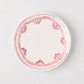 White appetizer plate with a hand-painted red fez border pattern.
