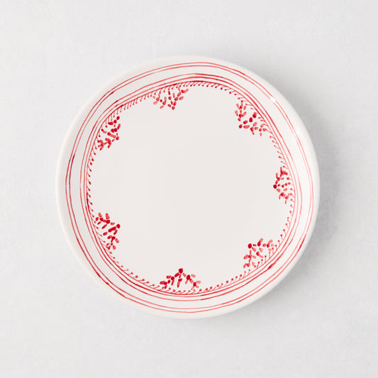 White appetizer plate with a hand-painted red fez border pattern.