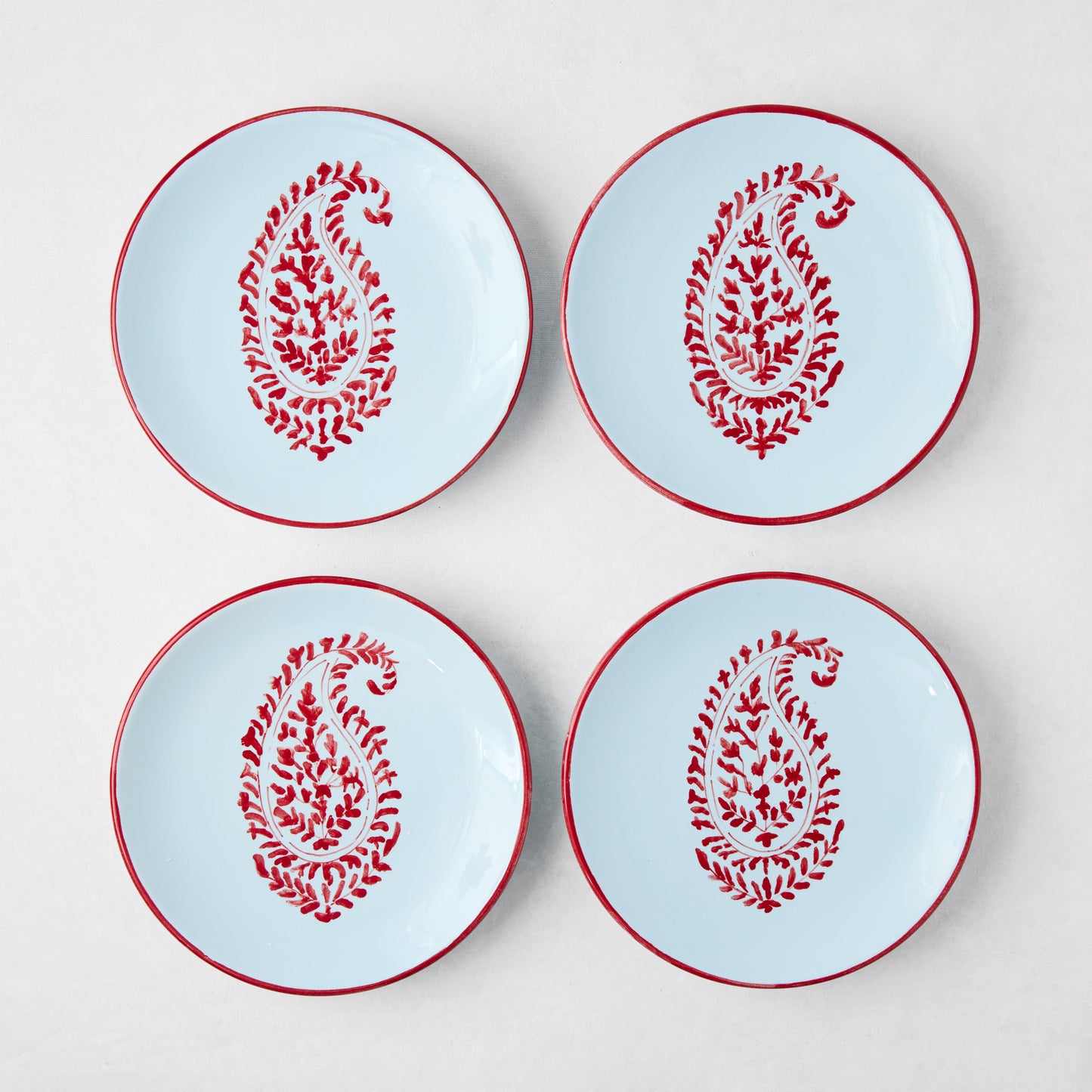 Four Peter Dunham + Hudson Grace Red Kashmir Paisley appetizer plates, light blue with red hand-painted design.