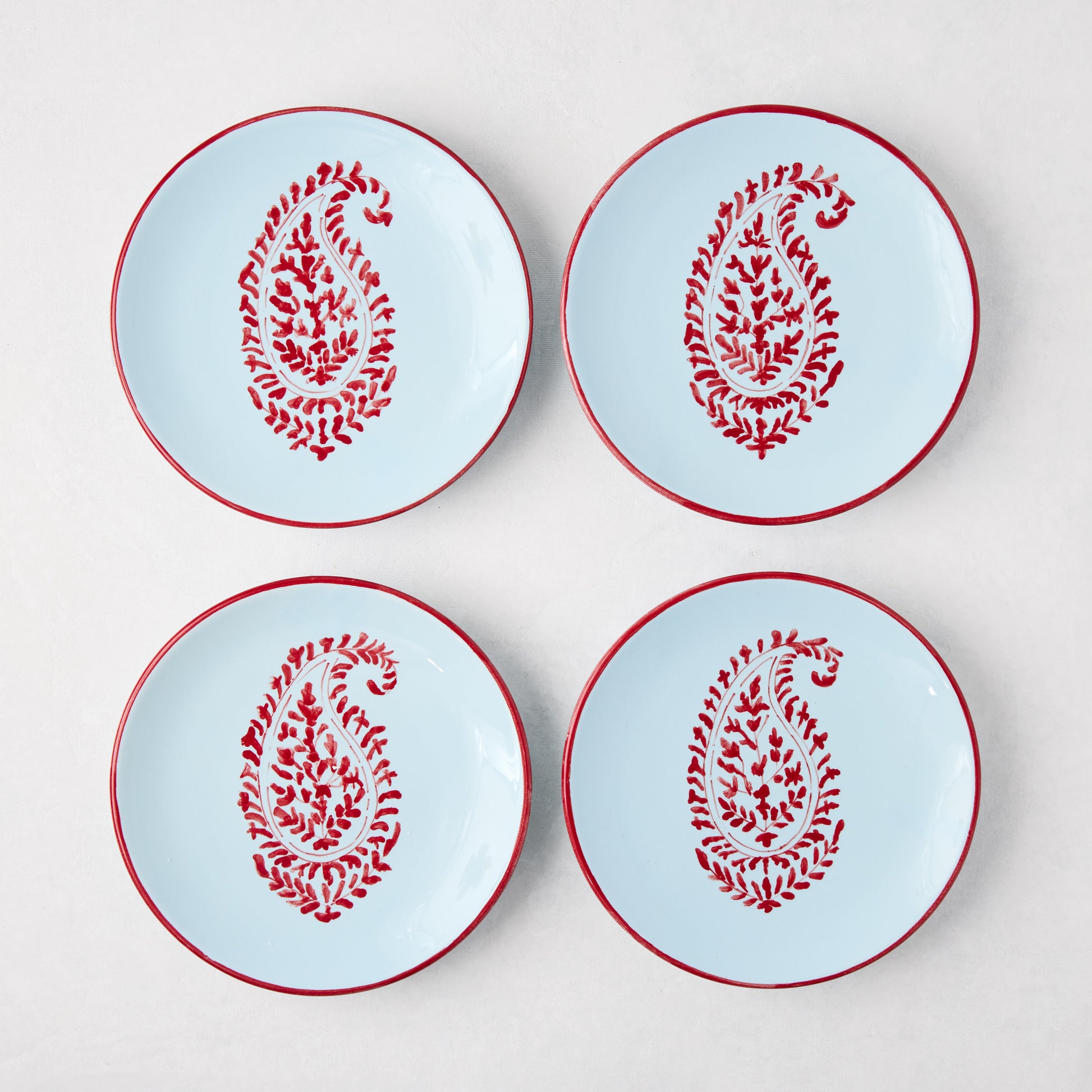 Four Peter Dunham + Hudson Grace Red Kashmir Paisley appetizer plates, light blue with red hand-painted design.