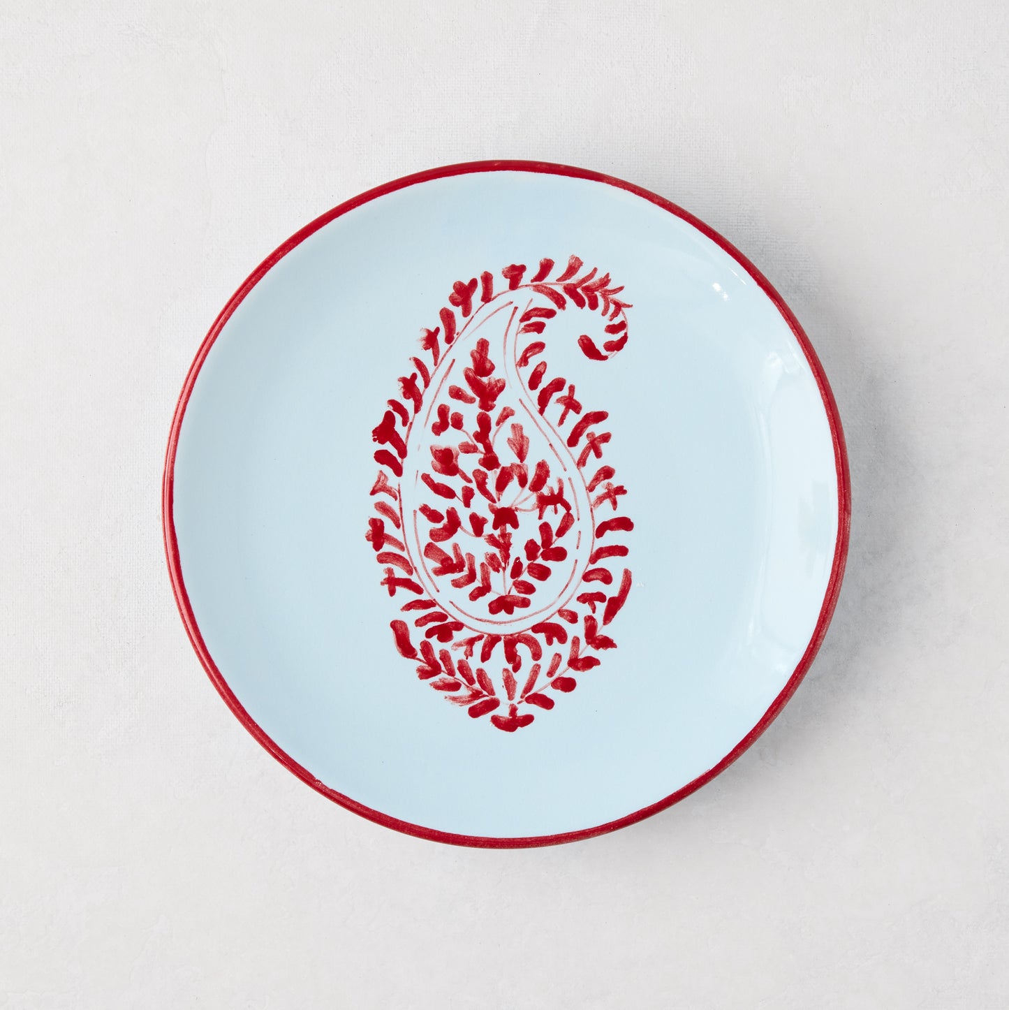 Peter Dunham + Hudson Grace Red Kashmir Paisley appetizer plate, hand-painted light blue ceramic with red trim.