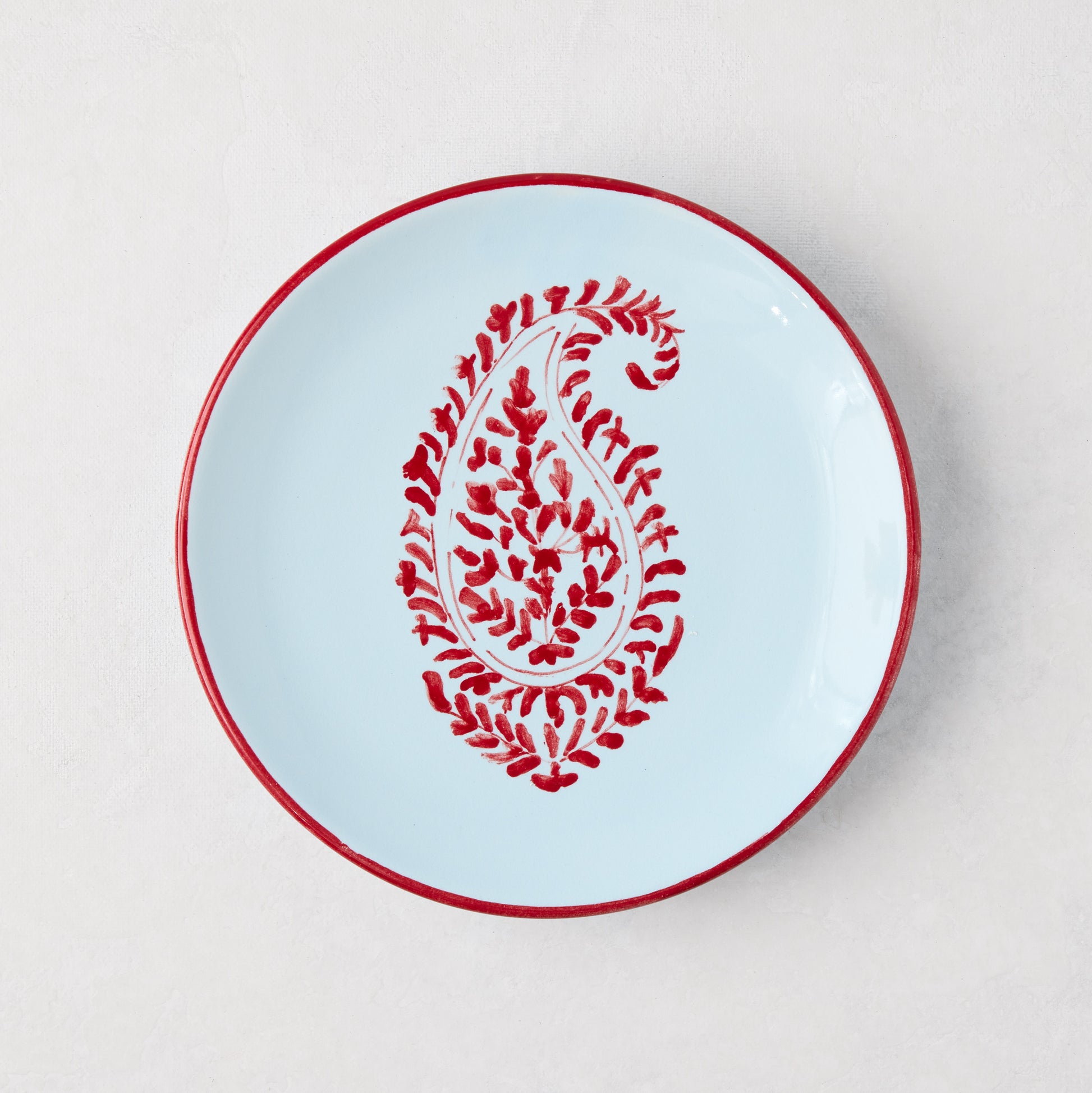 Peter Dunham + Hudson Grace Red Kashmir Paisley appetizer plate, hand-painted light blue ceramic with red trim.