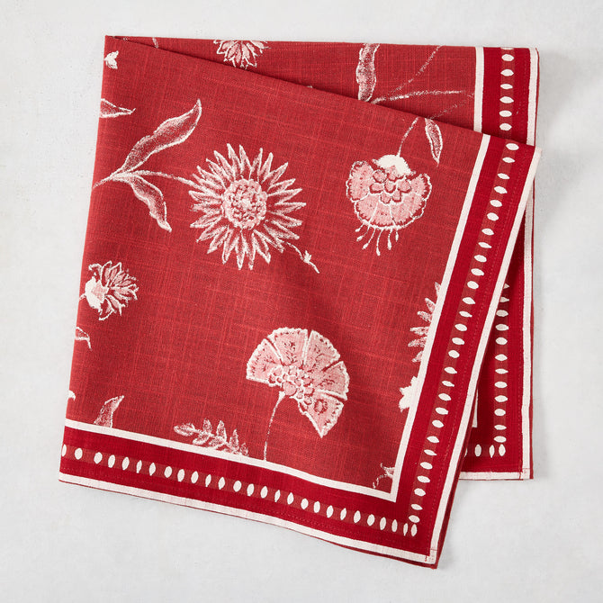 Red Indian Chintz cotton slub napkin with white floral print and dotted border.