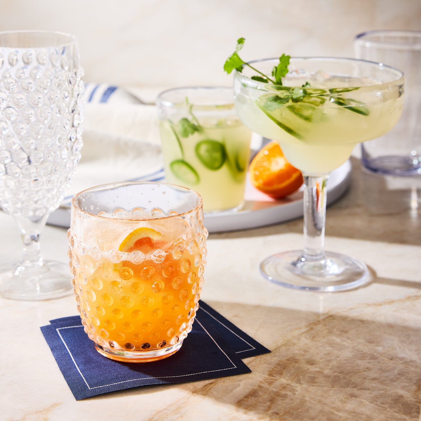 Petrol Blue Tear-Off Cotton Cocktail Napkins under a glass of orange cocktail.