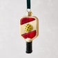 Glittered glass pickleball paddle ornament with red accents, yellow ball, and black handle, hanging from a green ribbon.