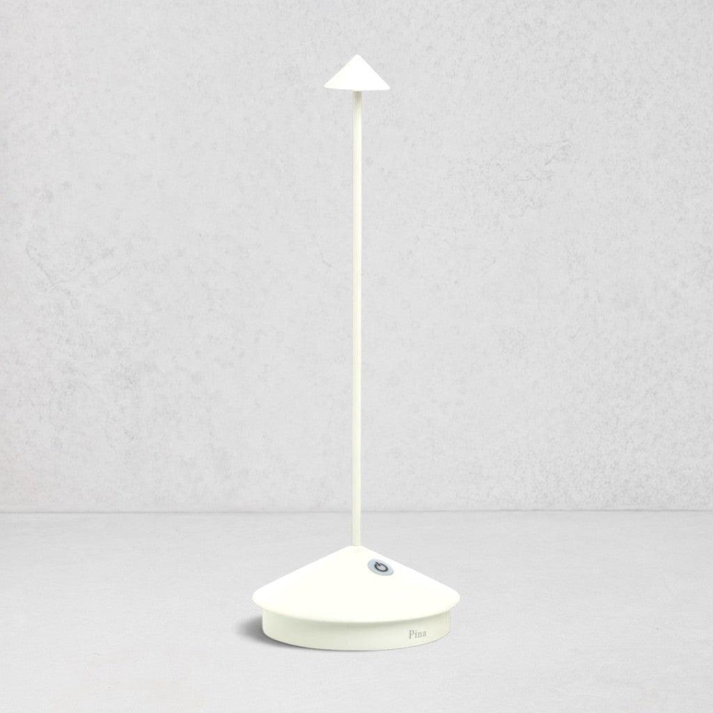White die-cast aluminum Pina Pro rechargeable LED table lamp with a broad base and thin rod.