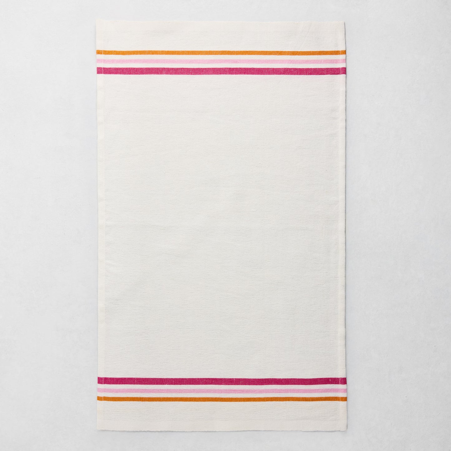 White cotton-linen hand towel with pink, orange, and fuchsia triple stripes at top and bottom.