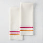 Set of 2 white cotton-linen hand towels with pink and orange triple stripes.
