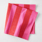 Folded Pink and Red Tonal Hampton Stripe Cotton Napkin, 22" square.