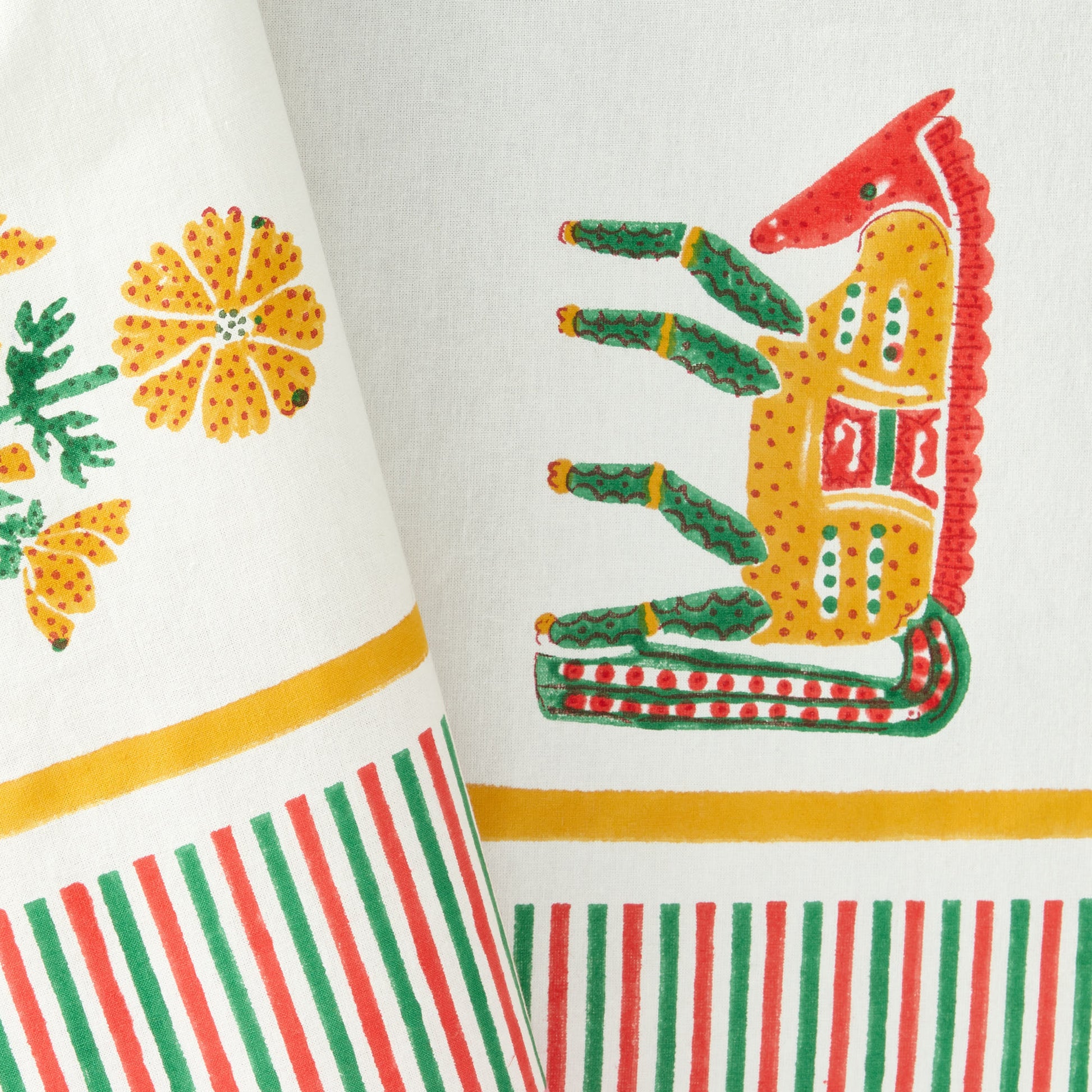 Pink cotton tablecloth with traditional block-printed horse and floral motifs, featuring a multicolored striped border.
