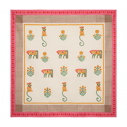 Pink block print cotton tablecloth with floral, horse, and monkey motifs, trimmed with a pink and multicolored edge.