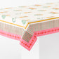 Pink cotton tablecloth with block-printed floral, horse, and monkey motifs and a multicolored striped and dotted border.