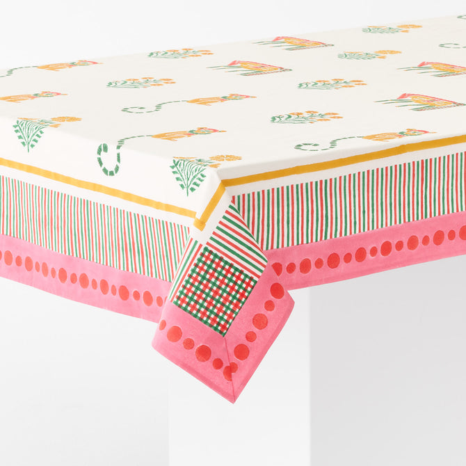 Pink cotton tablecloth with block-printed floral, horse, and monkey motifs and a multicolored striped and dotted border.
