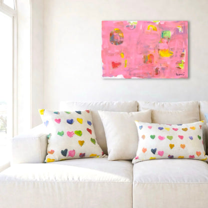 Kerri Rosenthal's "Pinkaholic" abstract art print, featuring vibrant pinks, yellows, and heart shapes, above a white sofa.