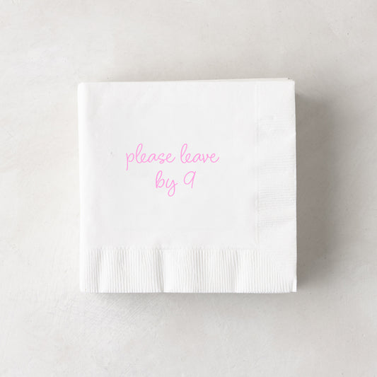White 3-ply paper cocktail napkin with "please leave by 9" in pink script, 5.5" square.