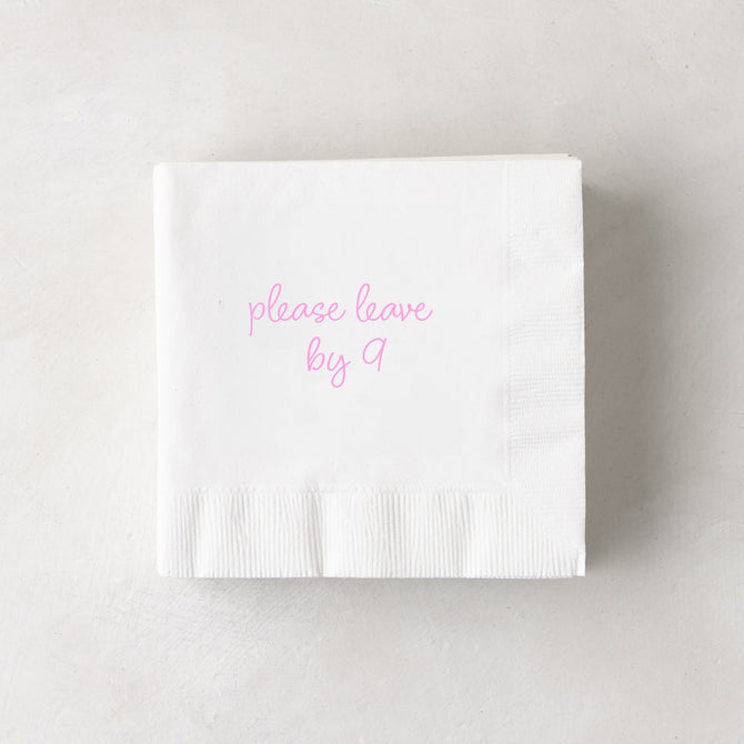 White 3-ply paper cocktail napkin with "please leave by 9" in pink script, 5.5" square.