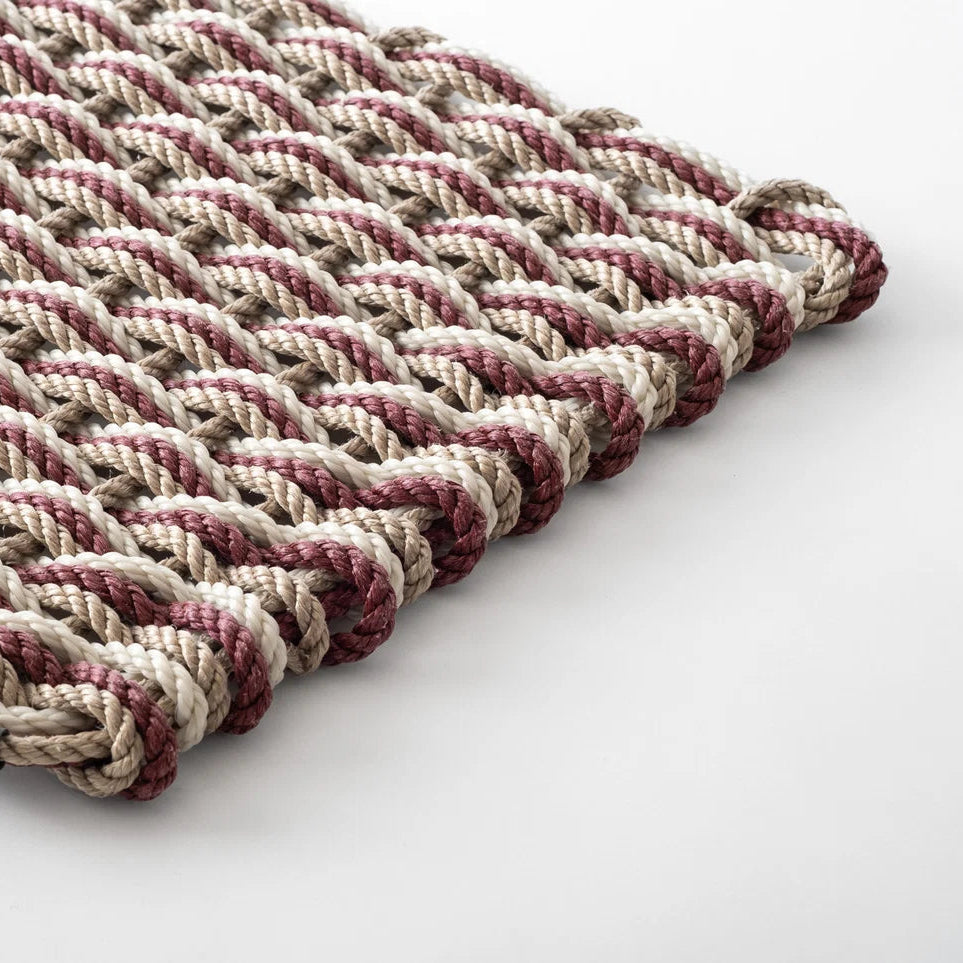 Hudson Grace handwoven all-weather rope doormat in pomegranate, sand, and oyster tones with a durable braided texture.