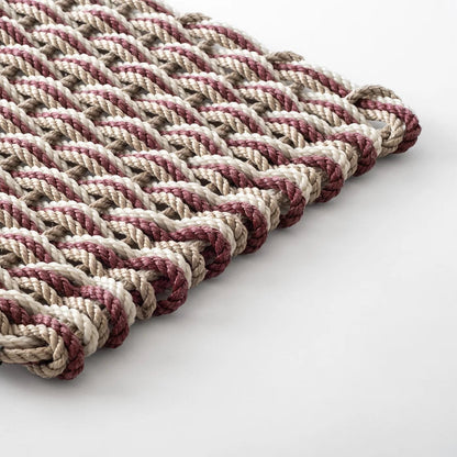 Hudson Grace handwoven all-weather rope doormat in pomegranate, sand, and oyster tones with a durable braided texture.