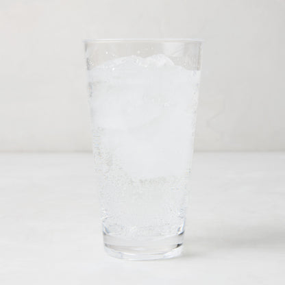 Clear acrylic highball glass with ice and sparkling water.