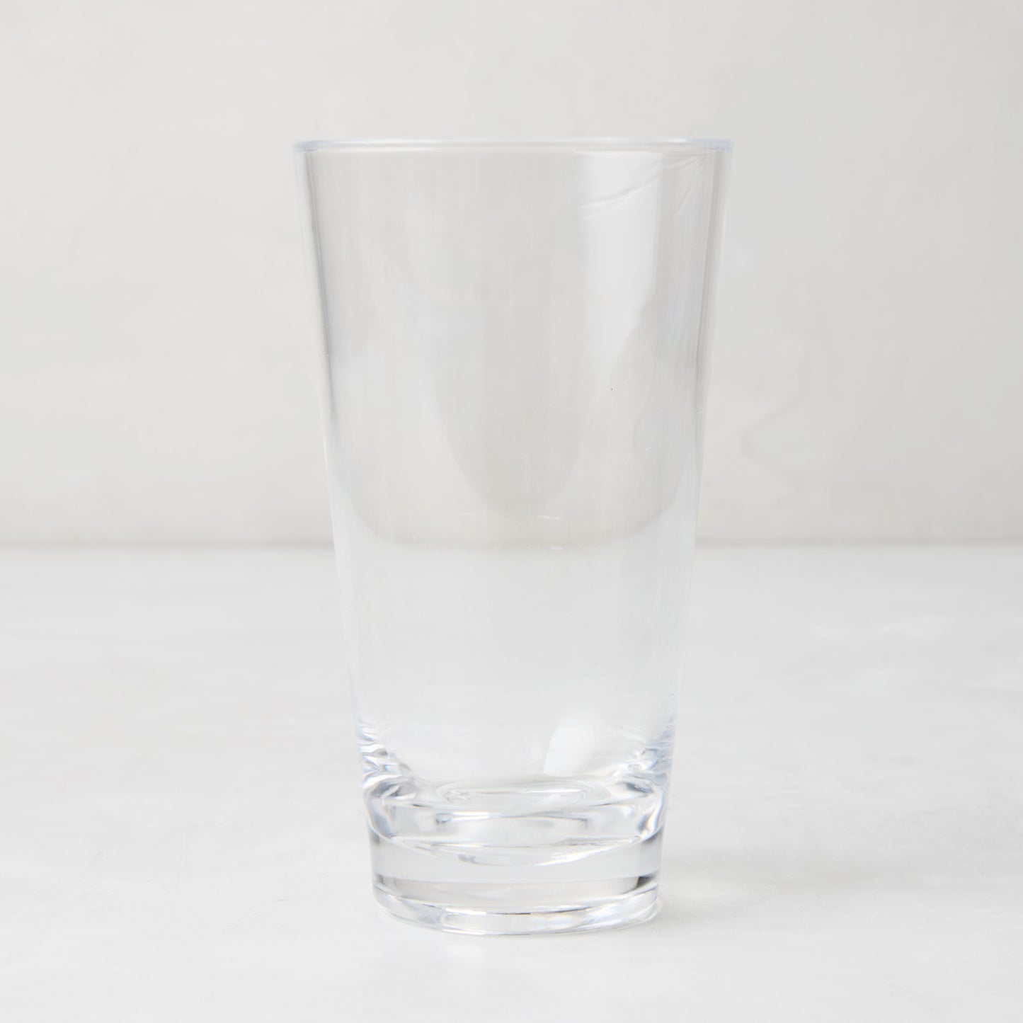 Clear acrylic high ball glass, 19oz, with a sturdy bottom and smooth lip.