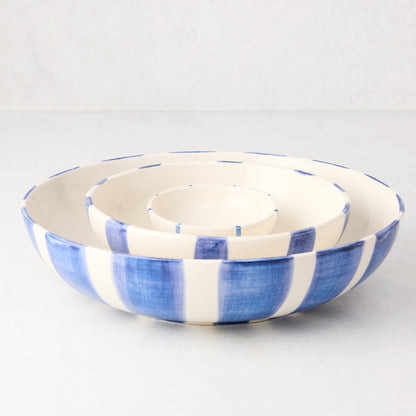 Three nested Portofino blue stripe ceramic serve bowls, large to small.
