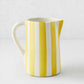 Medium Portofino ceramic pitcher with hand-painted yellow and white vertical stripes, curved handle and spout.